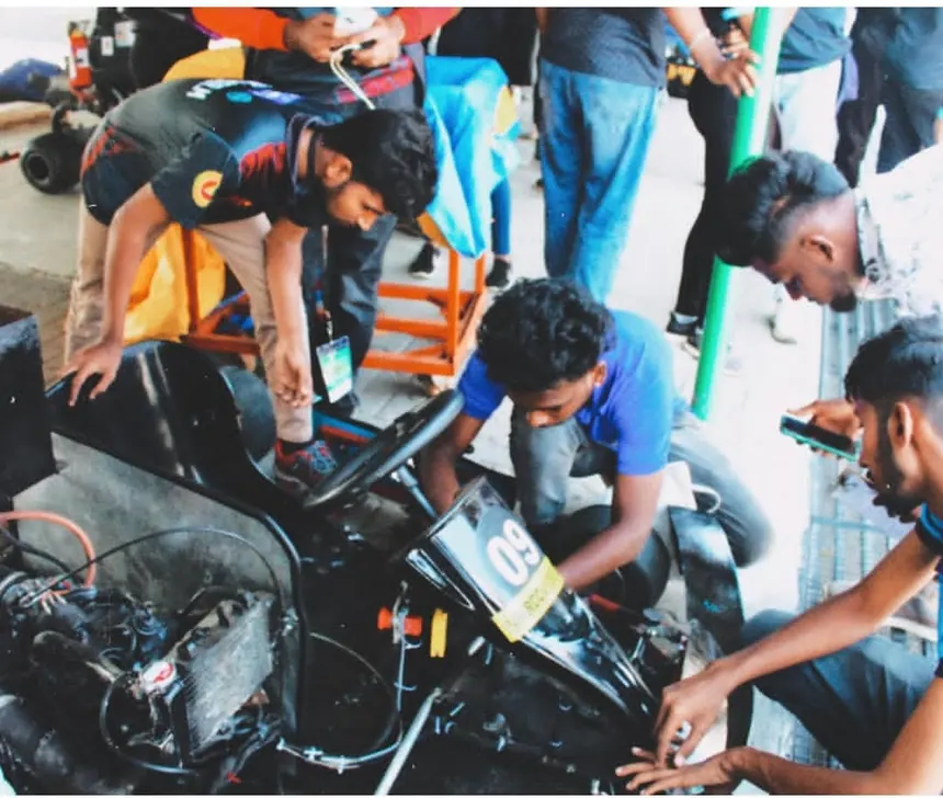 Several hands at once fitting hardware into the rear frame.
