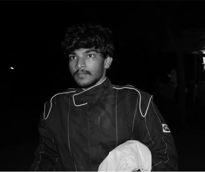 Black and white portrait of a driver in race overalls.